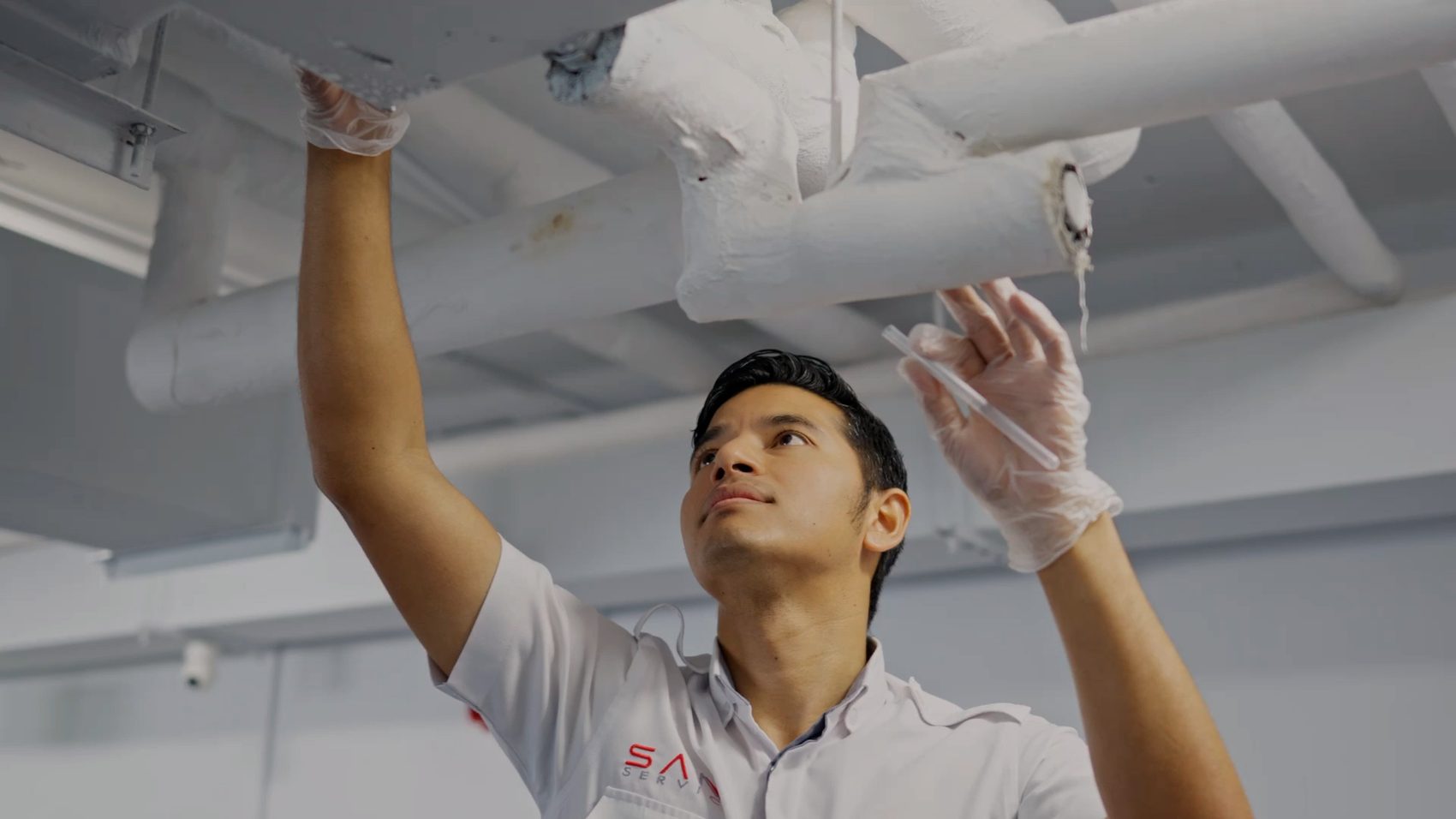 A Saniservice technician servicing a commercial HVAC system
