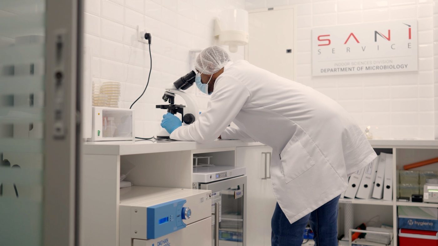 A Saniservice microbiologist at the microscope in the in-house Department of Microbiology