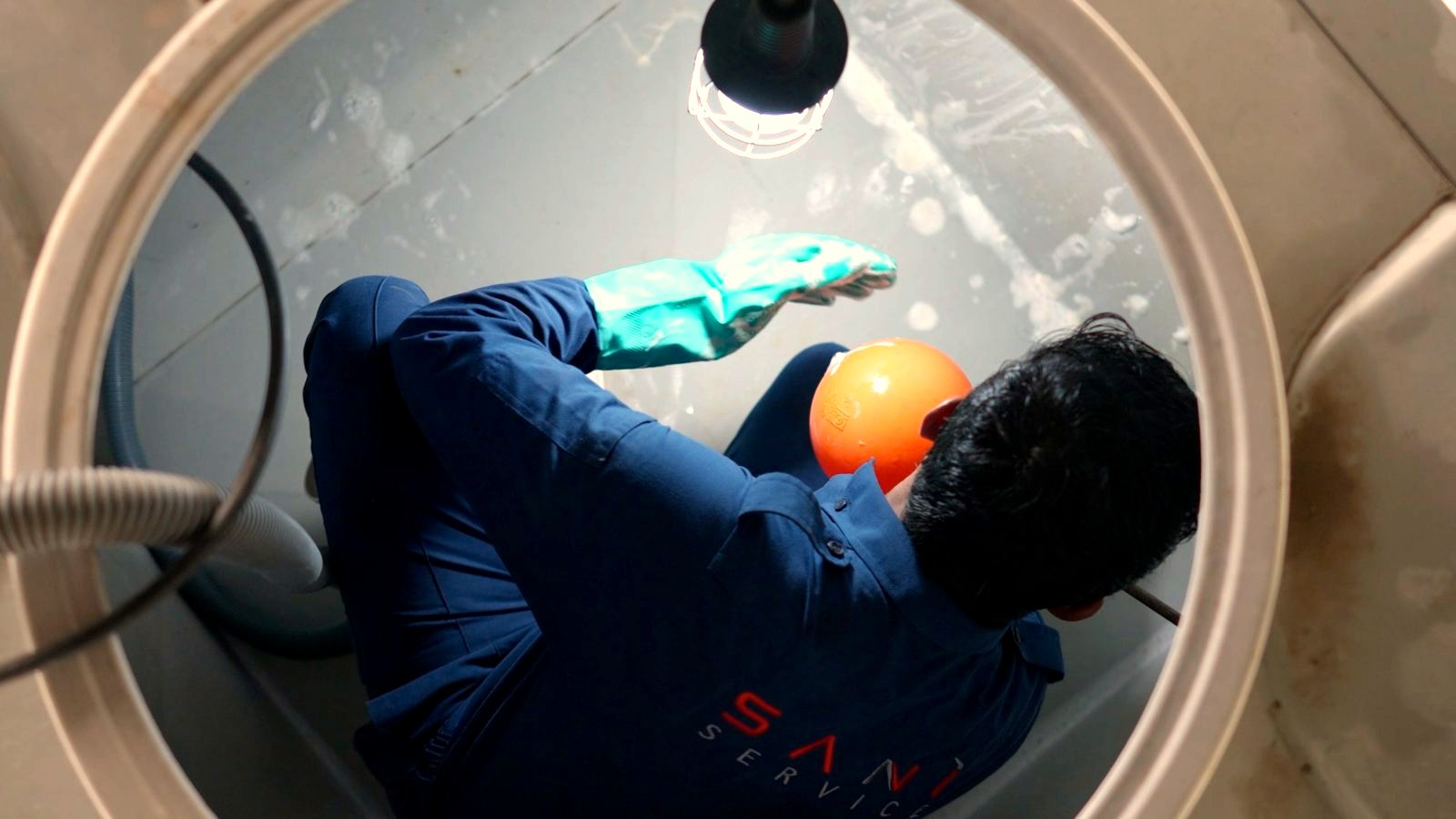 A Saniservice technician inside a water storage tank during cleaning and disinfection